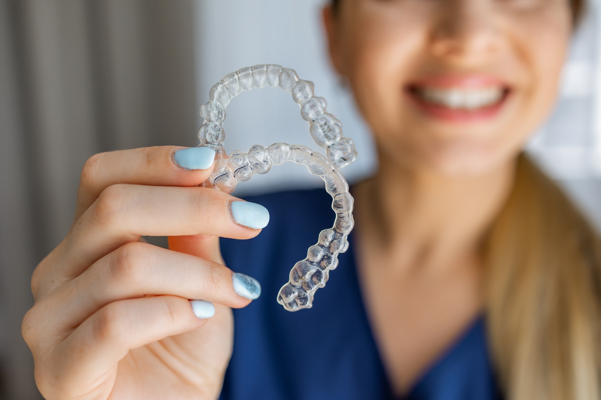 Woman holding clear Invisalign aligners
